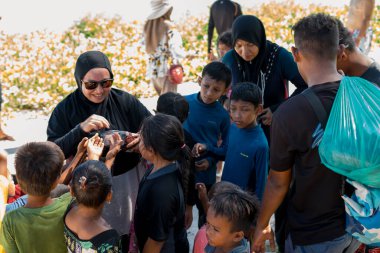 Sibuan, Malezya - 26 Kasım 2019: Köydeki Bajau Laut çocuklarına atıştırmalık ve mal dağıtan ziyaretçiler.