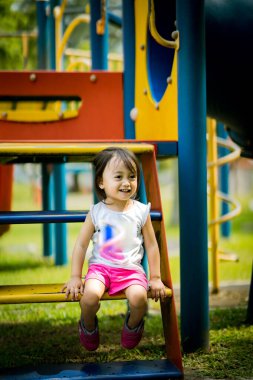 Küçük şirin Asyalı 2-3 yaşında, çocuk parkında küçük bir kız çocuğu. 