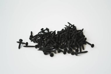 Beyaz arka planda izole edilmiş aynı boyutta siyah vidalar..