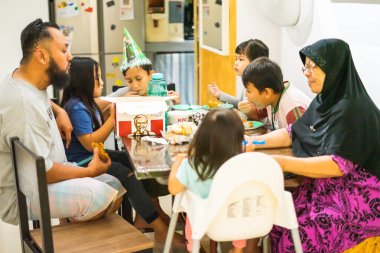 Selangor, Malezya - 8 Ağustos 2019: Partide doğum gününü kutlayan sevimli küçük Asyalı çocuk.