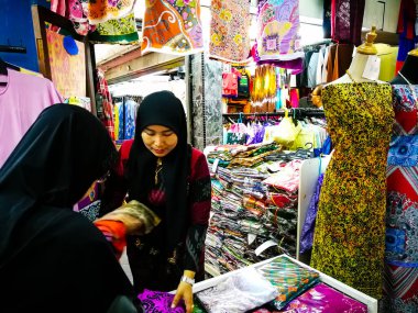 Piyasada farklı renkte ve renkli eşarplı geleneksel Arap kadın.
