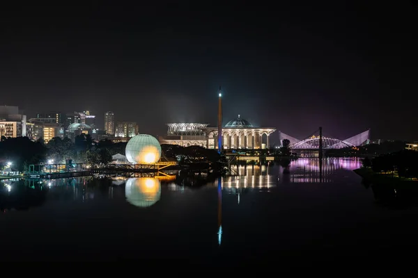 カラフルなモスク 熱気球とプトラジャヤ マレーシアの川の反射と橋で夜のシーン — ストック写真