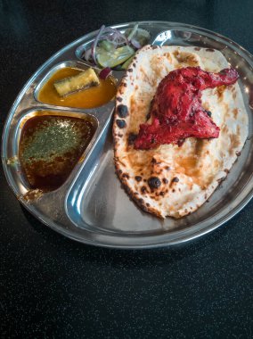 Hint Mutfağı Tandoori Roti ve Tavuk Metal Tabakta Servis Edilmiştir. Ayrıca Chapati, Yassı Ekmek, Naan veya Nan Ekmeği olarak da bilinir.