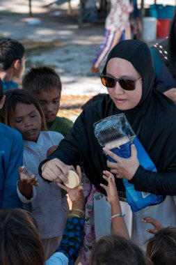 Sibuan, Malezya - 26 Kasım 2019: Köydeki Bajau Laut çocuklarına atıştırmalık ve mal dağıtan ziyaretçiler.