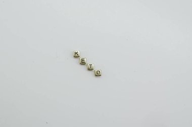 Keto diyeti beyaz arkaplanda altın zar bloklarıyla hecelenir.