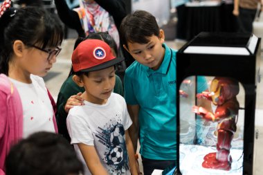 Kuala Lumpur, Malezya - 14 Eylül 2019: Malezya Uluslararası Ticaret ve Sergi Merkezi 'ndeki Demir Adam robotuna bakan çocuklar).
