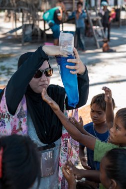 Sibuan, Malezya - 26 Kasım 2019: Köydeki Bajau Laut çocuklarına atıştırmalık ve mal dağıtan ziyaretçiler.