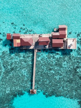 Turkuaz sudaki tropikal bir adanın havadan görünüşü. Tropikal ada beldesindeki su villaları üzerinde lüks.