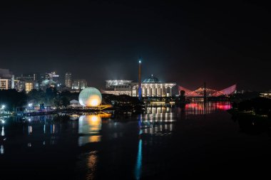Renkli camili gece sahnesi, sıcak hava balonu ve Putrajaya, Malezya 'daki nehir yansımalı köprü..