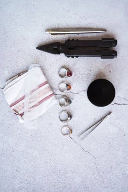 Şık erkek yüzükleri, kalem, aletler, mendil, poz ve tımar için parfüm. Beton arka planda metroseksüel sezaryenler. Şehir kompozisyonu. Üst görünüm.