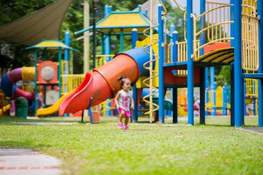 Mutlu Asyalı çocuk renkli oyun alanında eğleniyor..