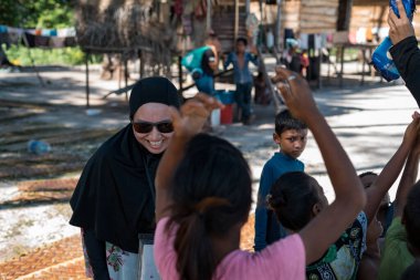 Sibuan, Malezya - 26 Kasım 2019: Köydeki Bajau Laut çocuklarına atıştırmalık ve mal dağıtan ziyaretçiler.