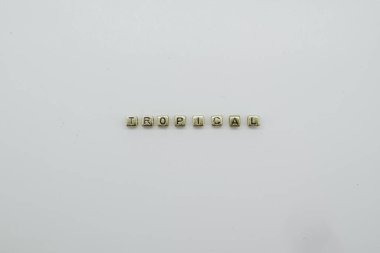 TROPICAL Kelime altın renkli bloklardan yapılır.