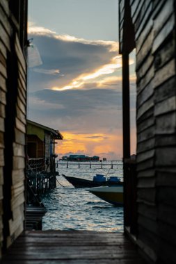 Teknelerin silueti ve kimliği belirsiz bir adam sabahın erken saatlerinde Semporna, Sabah, Malezya 'da çalışıyorlar..