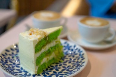 Tabağa bir dilim çikolatalı pasta. Yeşil renkli Gula Melaka pastası. Kahve keki çay zamanı konsepti.