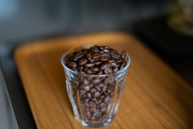 Bardaktaki kahve çekirdekleri ahşap arka planda..