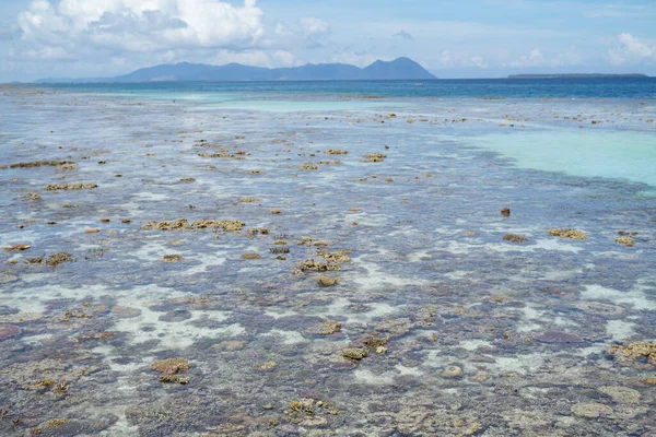 沙巴湾海岛上一个空旷的半波尔纳海滩上低潮时露露在水面上的粗糙珊瑚礁的美丽风景 — 图库照片