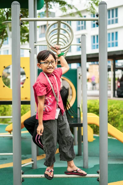 若いアジアの子供たちはサルのバーにかかっている 近所の屋外遊び場で運動するには — ストック写真