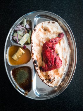 Hint Mutfağı Tandoori Roti ve Tavuk Metal Tabakta Servis Edilmiştir. Ayrıca Chapati, Yassı Ekmek, Naan veya Nan Ekmeği olarak da bilinir.