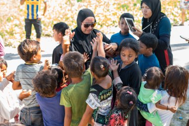 Sibuan, Malezya - 26 Kasım 2019: Köydeki Bajau Laut çocuklarına atıştırmalık ve mal dağıtan ziyaretçiler.