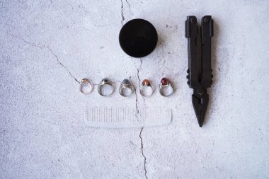 Şık erkek yüzükleri, kalem, aletler, mendil, poz ve tımar için parfüm. Beton arka planda metroseksüel sezaryenler. Şehir kompozisyonu. Üst görünüm.