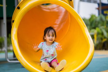 Çocuk parkında oynayan iki yaşındaki Asyalı kız ya da çocuk. Sağlıklı yaşam tarzları konsepti.