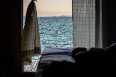 Deniz manzaralı arka plan, çocuklar yatağın üzerinde uyur ve suya bakar..