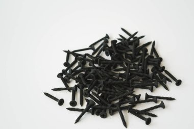 Beyaz arka planda izole edilmiş aynı boyutta siyah vidalar..