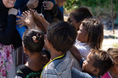 Sibuan, Malezya - 26 Kasım 2019: Köydeki Bajau Laut çocuklarına atıştırmalık ve mal dağıtan ziyaretçiler.