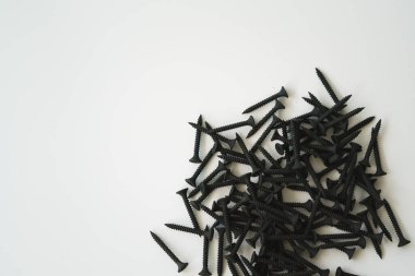 Beyaz arka planda izole edilmiş aynı boyutta siyah vidalar..