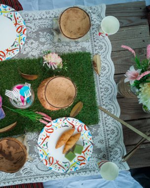 Parkta çevre dostu piknik. Masa örtüsü, geri dönüştürülmüş tabaklar, sağlıklı yiyecekler ve aksesuarlar, üst manzara.