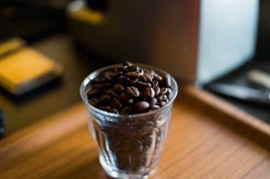 Bardaktaki kahve çekirdekleri ahşap arka planda..