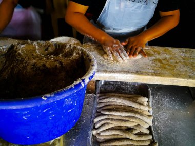 Fırıncı arka planda mutfakta tatlı yapıyor.