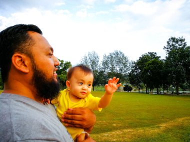 Baba ve oğlu arka planda.