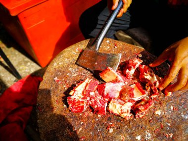 Açık havada baltayla tahtadan et keserek..