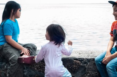 Kardeşler oturmuş denizin esintisinin tadını çıkarıyorlar..