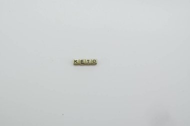 Keto diyeti beyaz arkaplanda altın zar bloklarıyla hecelenir.