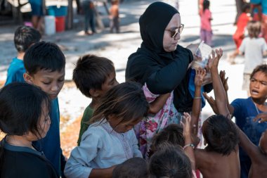 Sibuan, Malezya - 26 Kasım 2019: Köydeki Bajau Laut çocuklarına atıştırmalık ve mal dağıtan ziyaretçiler.