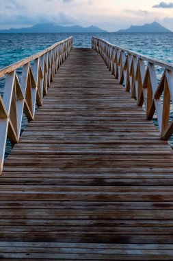 Borneo Sabah Semporna 'daki Bum bum adasının yakınındaki günbatımında tahta köprü..