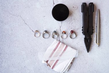 Şık erkek yüzükleri, kalem, aletler, mendil, poz ve tımar için parfüm. Beton arka planda metroseksüel sezaryenler. Şehir kompozisyonu. Üst görünüm.