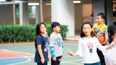 Bangi, Malezya - 10 Temmuz 2019: Çocuklar beyzbol sahasında mutlu bir şekilde oynuyorlar. Toplum çocukları birlikte oynuyorlar..