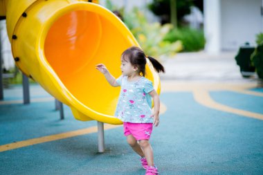 Küçük şirin Asyalı 2-3 yaşında, çocuk parkında küçük bir kız çocuğu. 