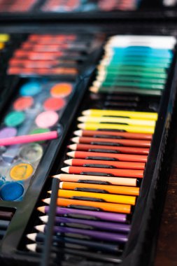 Masa başı görünümünde malzemeler, okul yaratıcı işleri için yaratıcı araçlar, boyama kağıtları, boya fırçaları kalem boyaları, resim malzemeleriyle arka plan,