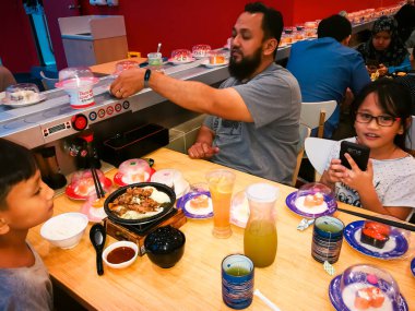 Nilai, Malezya - 3 Haziran 2019: Aileler Aeon NIlai, Negeri Sembilan 'daki Restoran Suşi Kralı' nda Japon yemeklerini yiyorlar.