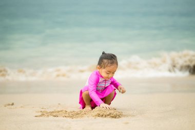 Sahilde oynayan küçük Asyalı kız. Tatil ve rahatlama konsepti..