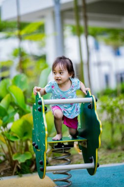 Küçük şirin Asyalı 2-3 yaşında, çocuk parkında küçük bir kız çocuğu. 