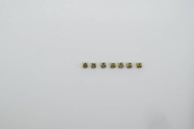 kaygı beyaz zemin üzerinde altın zar blokları ile hecelenir.