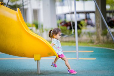 Küçük şirin Asyalı 2-3 yaşında, çocuk parkında küçük bir kız çocuğu. 