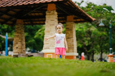 Parkta Asyalı çocuk oynuyor.  