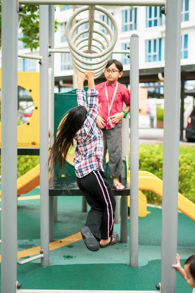 아시아인 아이들은 원숭이바에 매달려 있습니다 근처의 놀이터에서 운동하는 — 스톡 사진